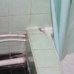 Bathroom with broken shower tiles before repair