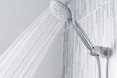 Clean bathroom shower with close up of shower head spraying water