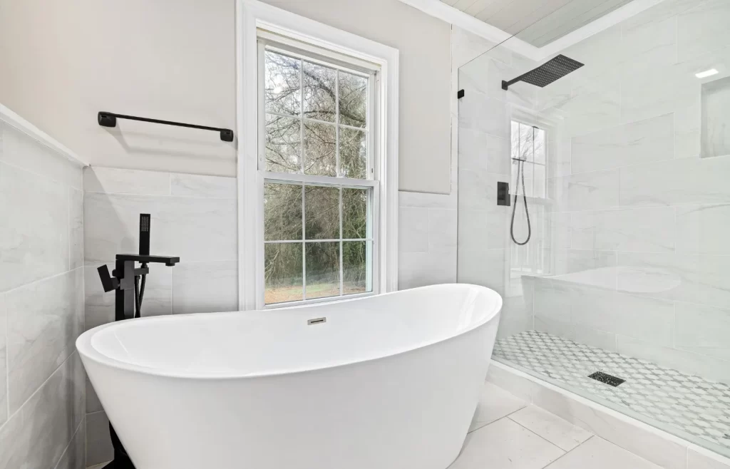 White spacious bathroom with bathtub beside a window