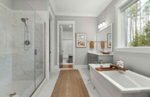 Modern tiled bathroom with glass shower screen, bathtub and vanity, highlighting shower waterproofing and wet area protection.